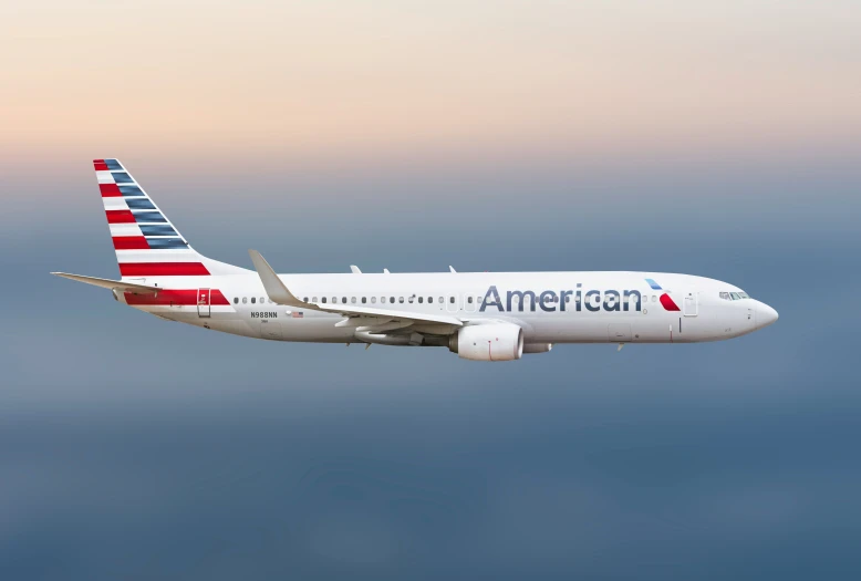 a red, white and blue plane flies in the air