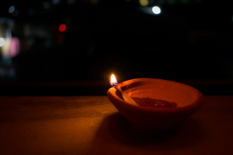 candle in a wooden bowl on a table