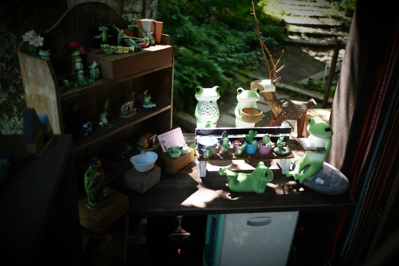 an assortment of small green stuffed animals on a wooden table