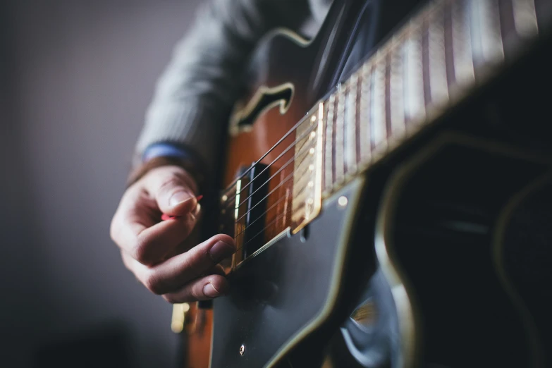 a person playing an acoustic guitar while holding it