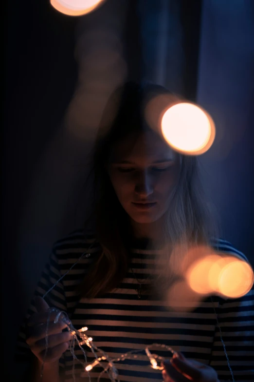 a woman standing in front of a wall holding a phone