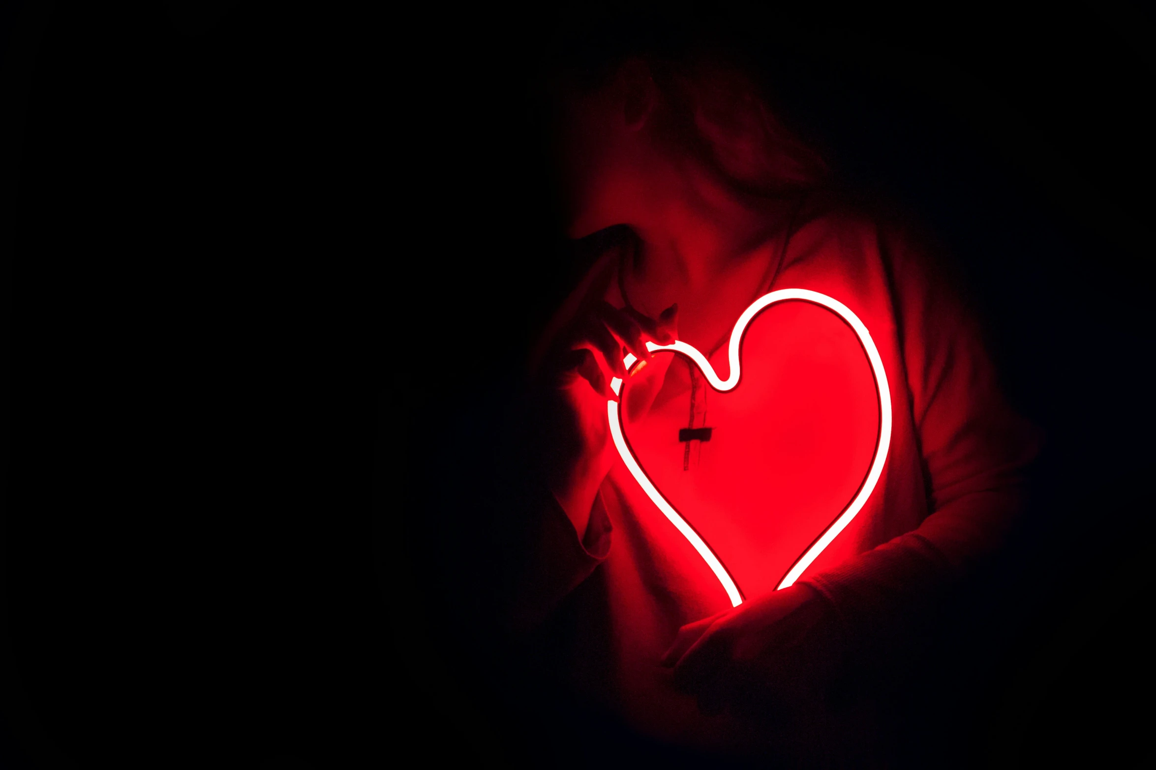 a red heart that is glowing red in the dark