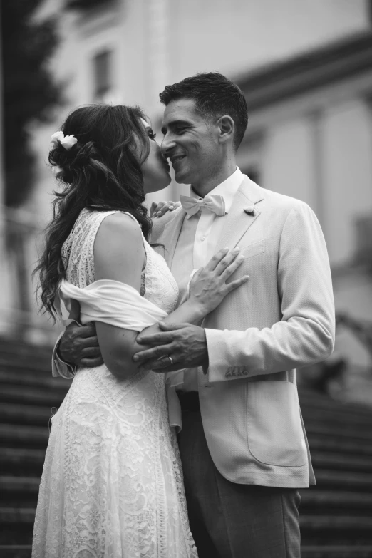 a bride and groom pose for a picture outside