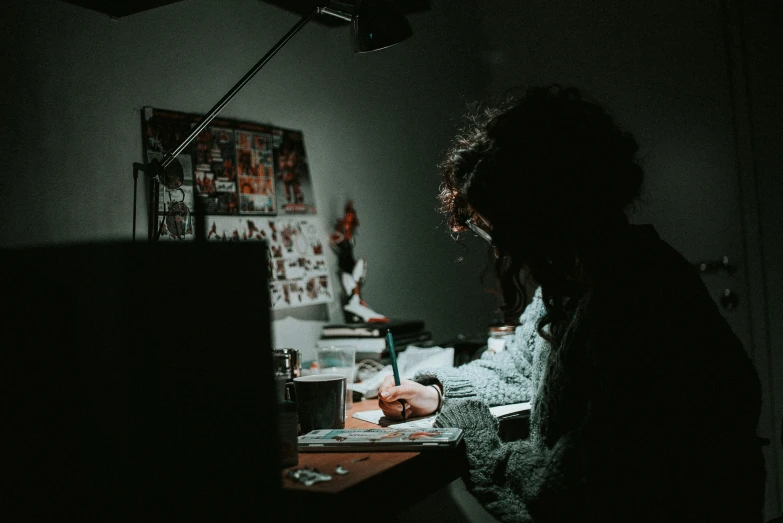 a dark room with a person working at a desk