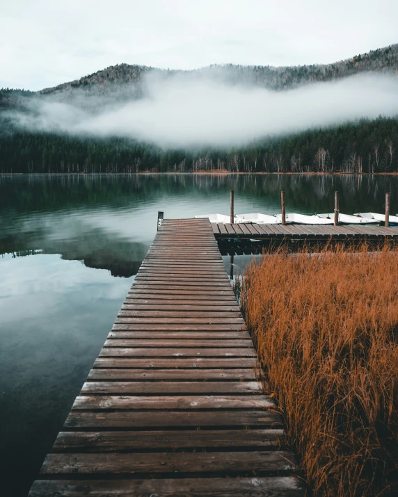 a dock in front of water with fog on the sky