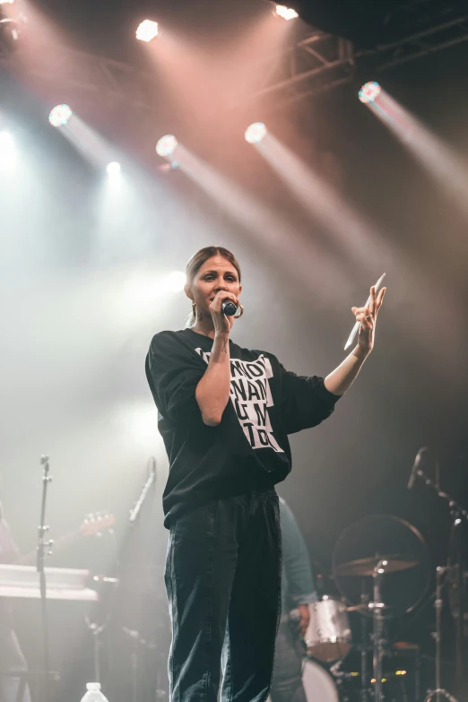 a man holding a microphone on stage with smoke