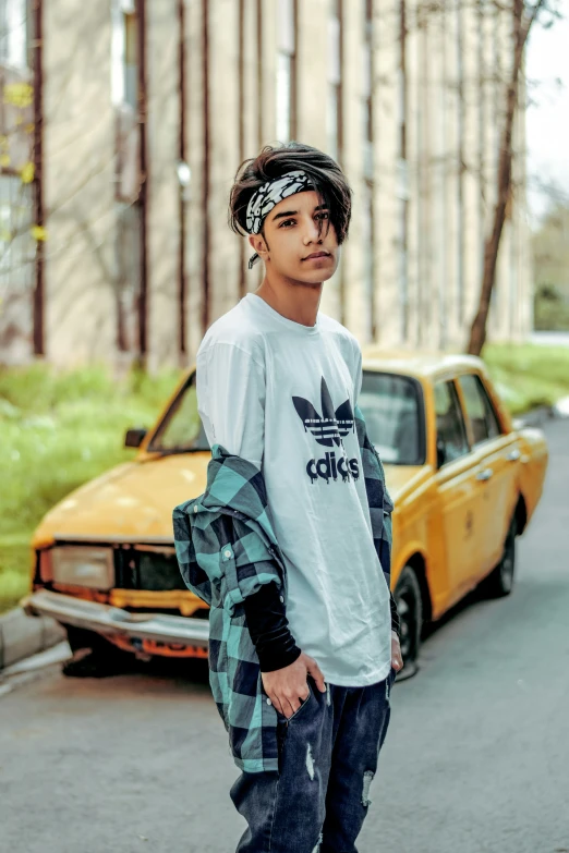 the skateboarder is leaning against the wall and wearing his adidas t - shirt