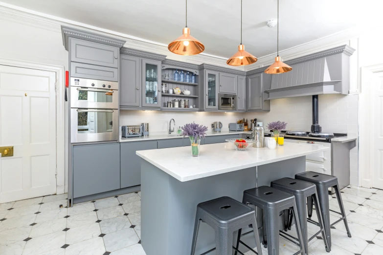 a kitchen with a lot of gray cabinets and counters