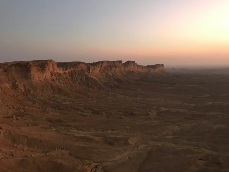 an aerial view of the sun setting over an arid desert