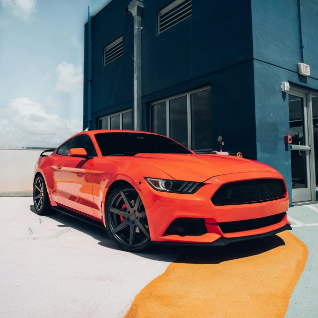 a red ford mustang parked on the side of the road