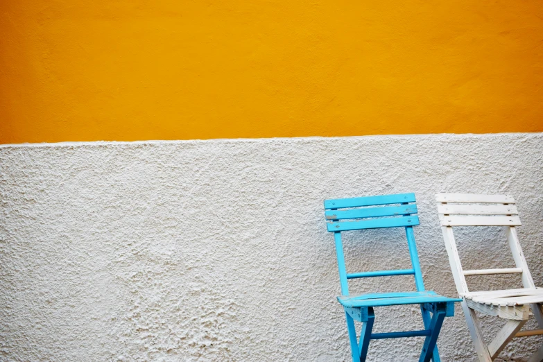 two chairs against a wall near a chair