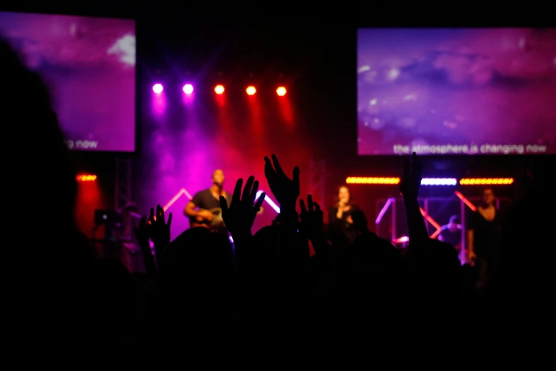 a large crowd of people with their hands in the air