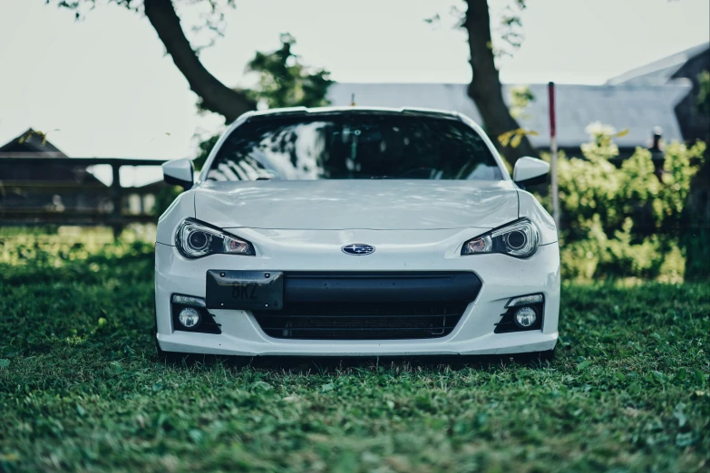 a white sports car parked in a field of green grass