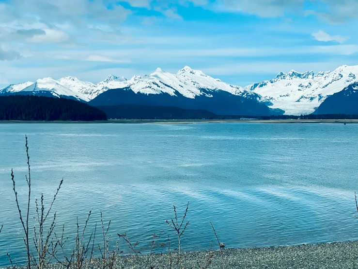 water and mountains are in the distance under a cloudy sky