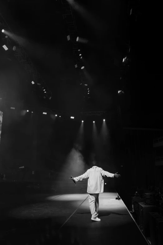 a man walking down a runway in front of light streams