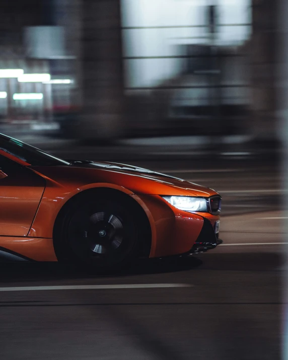 a po of the orange sport car driving down the street