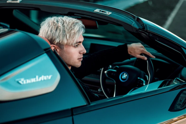 a person in a blue car with a white hair