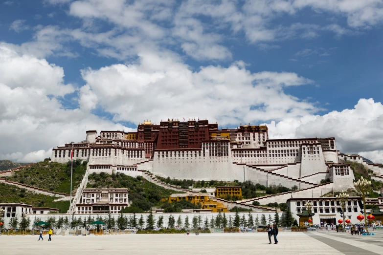 there is a mountain side city with a large building on top of it