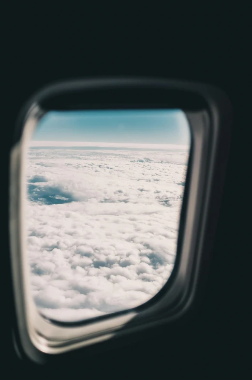 an airplane window with clouds above and below