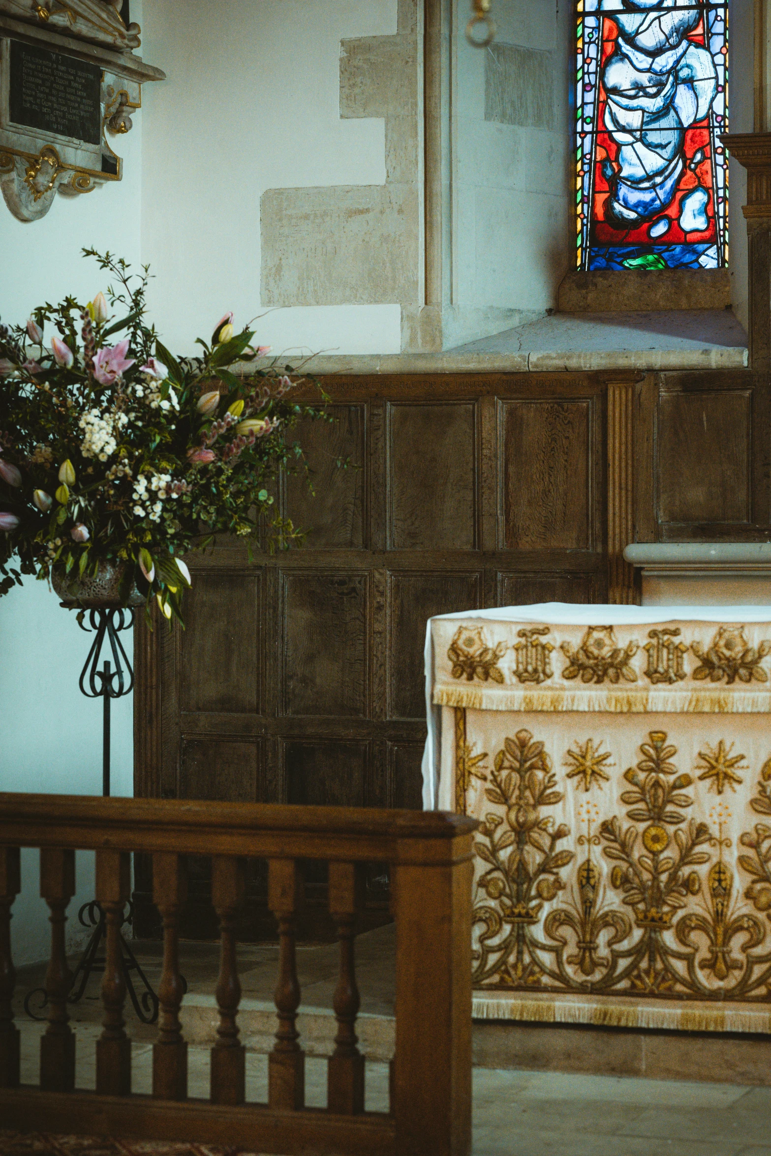 an ornate floral casket next to a stained glass window