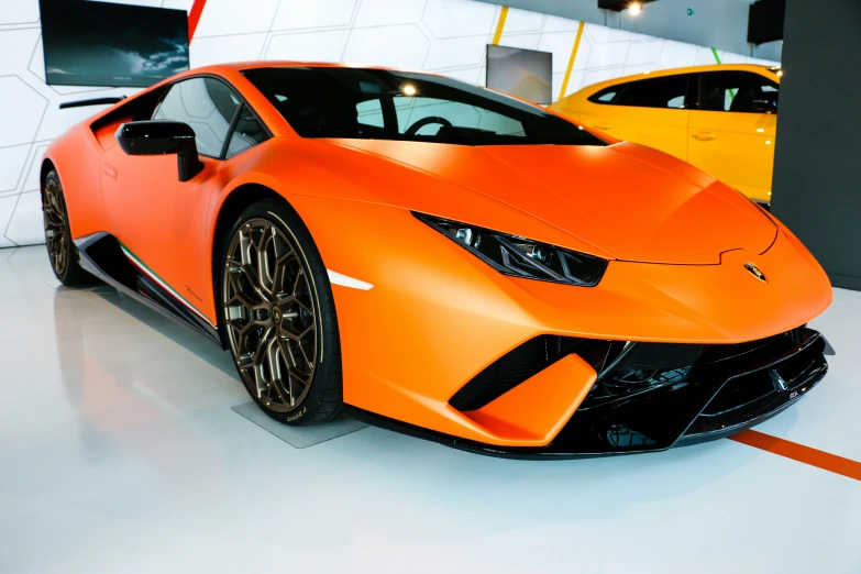 a car that is orange and white in a show room