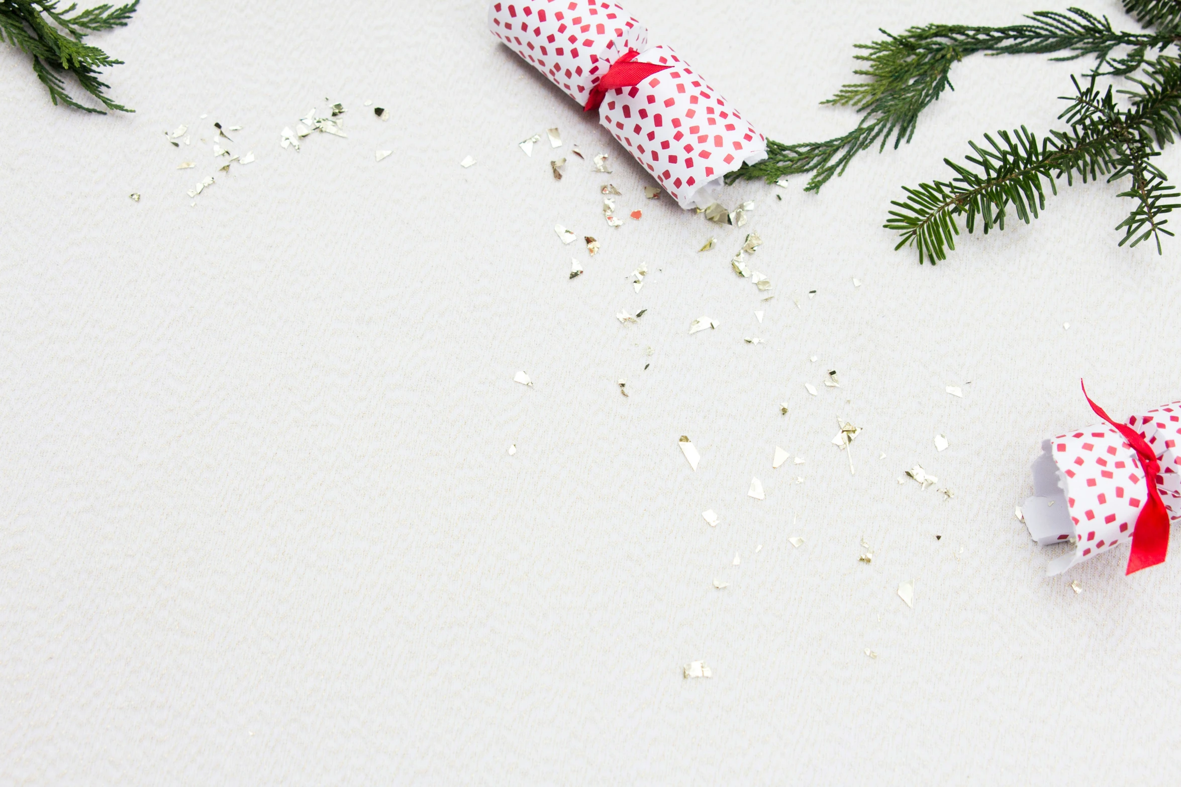 two wrapped presents sit near the evergreen nches