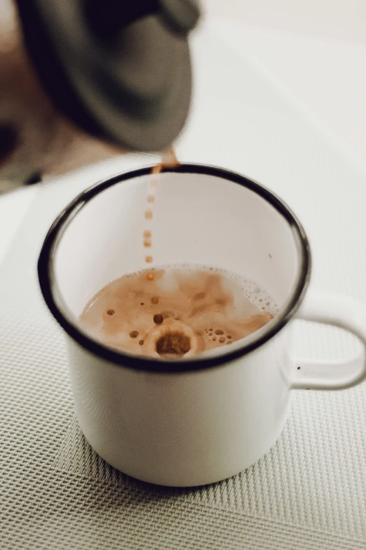 a cup full of liquid that is on a table