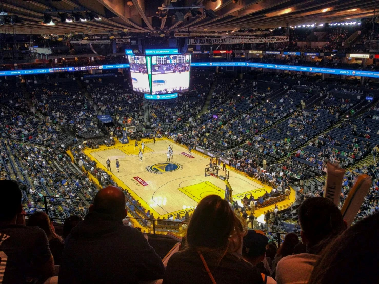 a basketball game on a big court with an audience