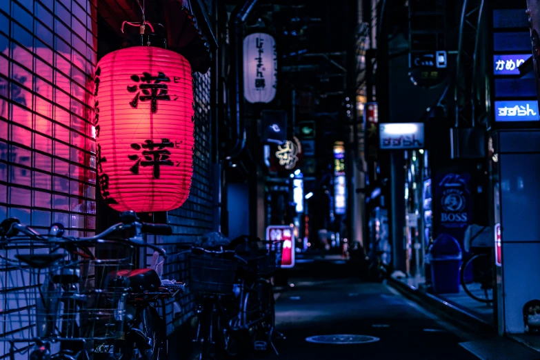 an alleyway with lanterns and bicycles in the night