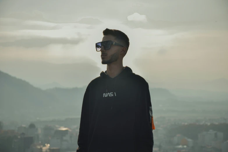 a person with a dark sweatshirt wearing sunglasses on