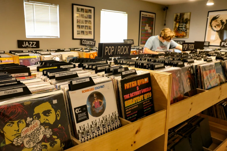 some records on display in a store with wooden shelves