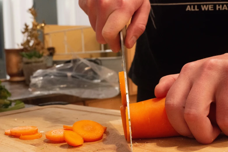 a man is using a knife to cut carrots