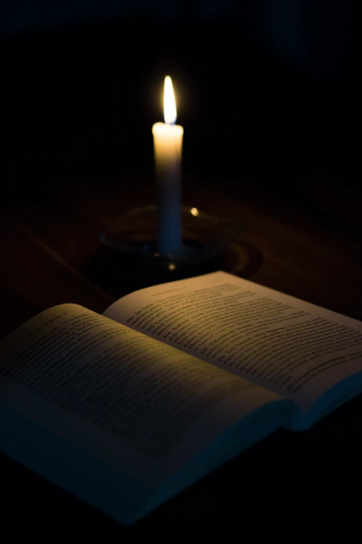 the candle is glowing brightly over an open book