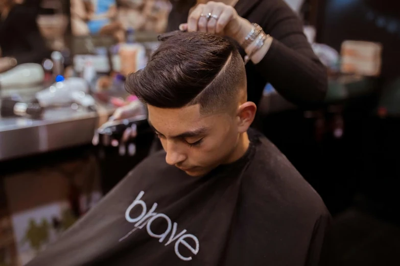 a man getting his haircut in front of a barber shop