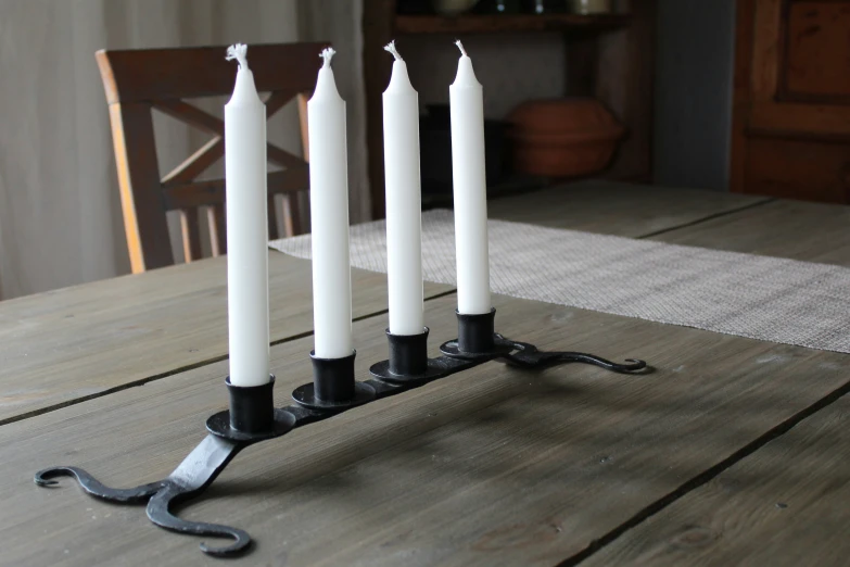 seven candles on an iron stand on a table