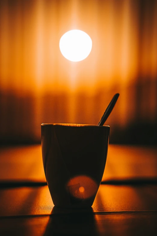 a spoon in a cup sitting on a table