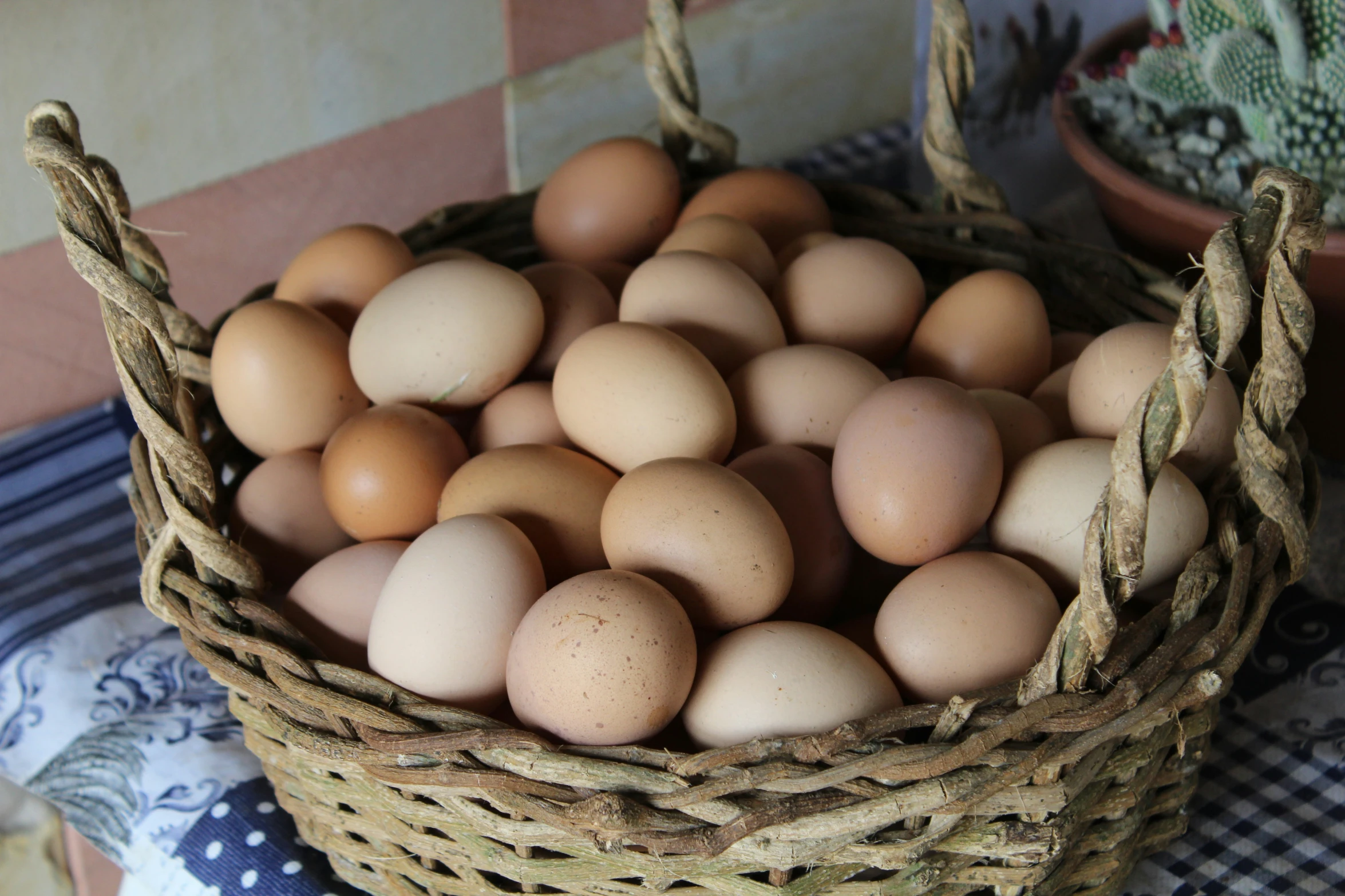 a wicker basket filled with eggs on a table