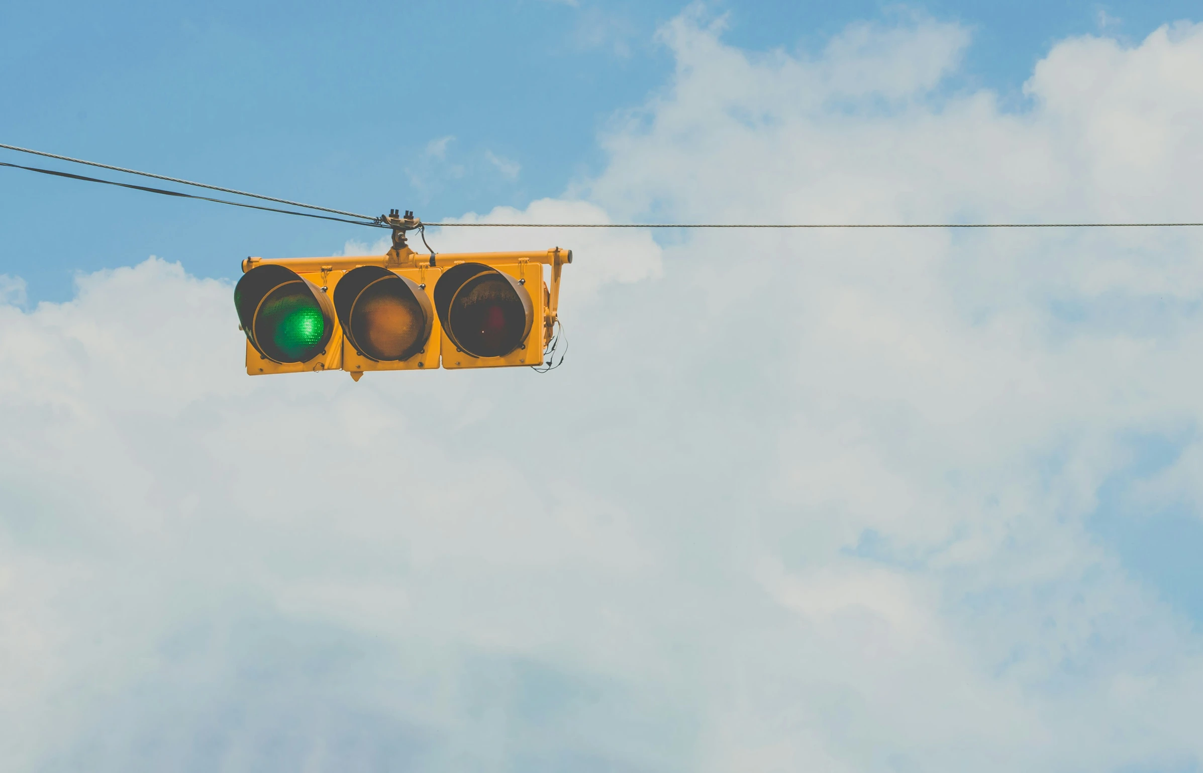 a traffic signal is in the air on a cloudy day