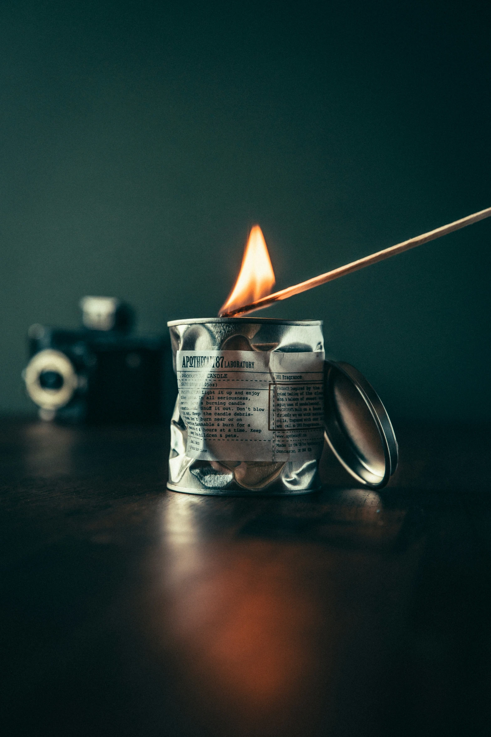 two tin cans on a table with a fire stick in one