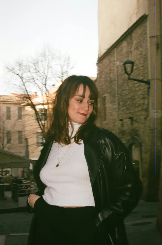 the young lady wearing black is standing next to a building