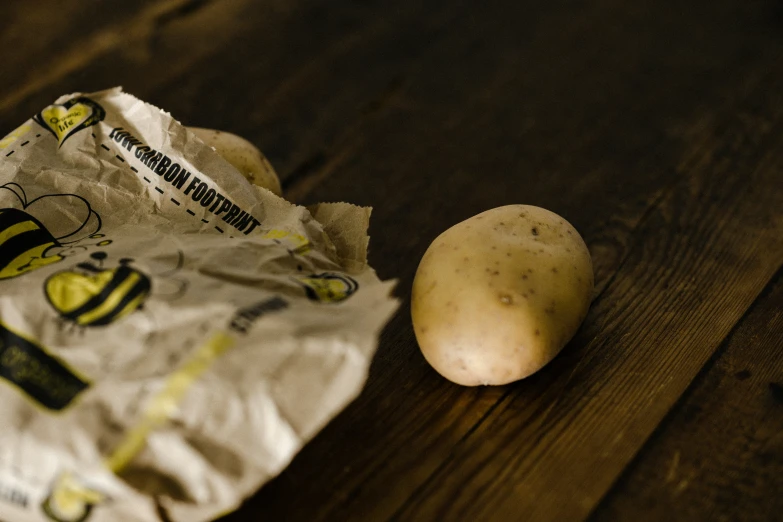 a peeled potato and piece of plastic wrap sitting on the floor