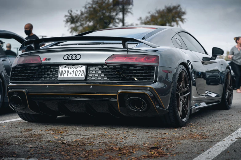 a grey sports car with an exhaust pipe sits parked