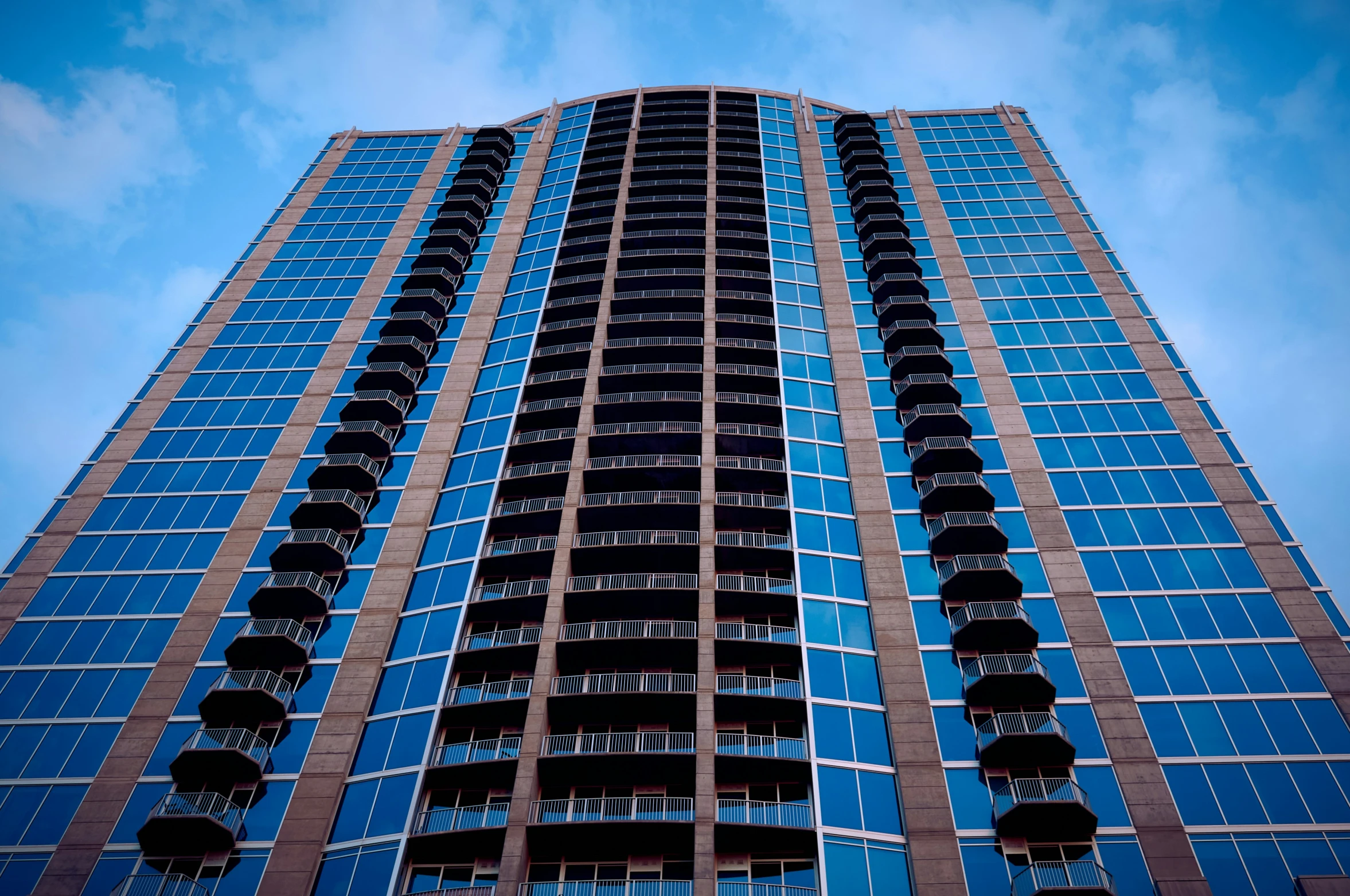 a building in the city with several stories and blue glass windows