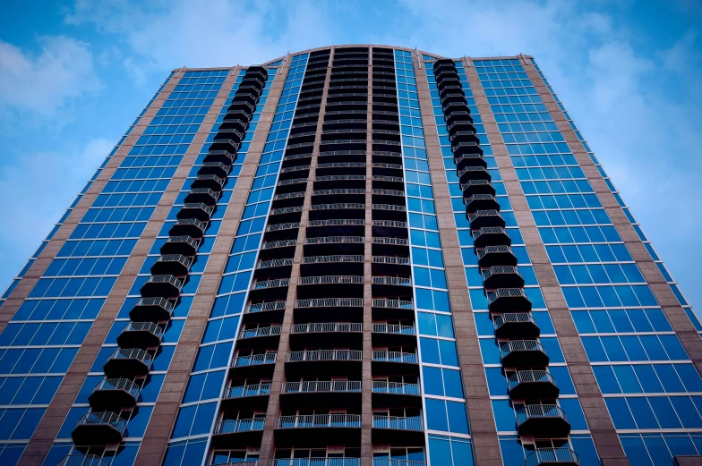 a building in the city with several stories and blue glass windows