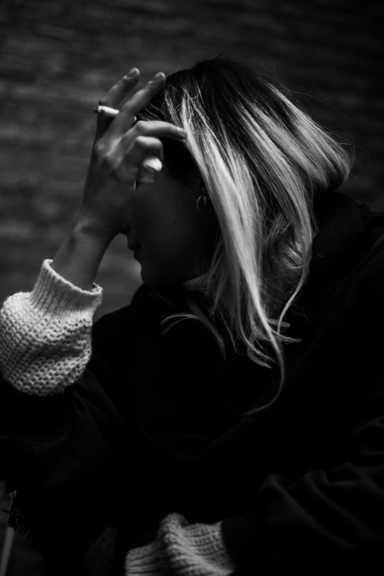 a beautiful young woman with long blonde hair holding up a cigarette