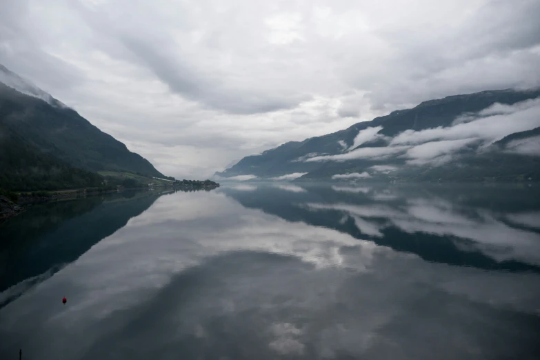 a calm mountain lake under cloudy skies