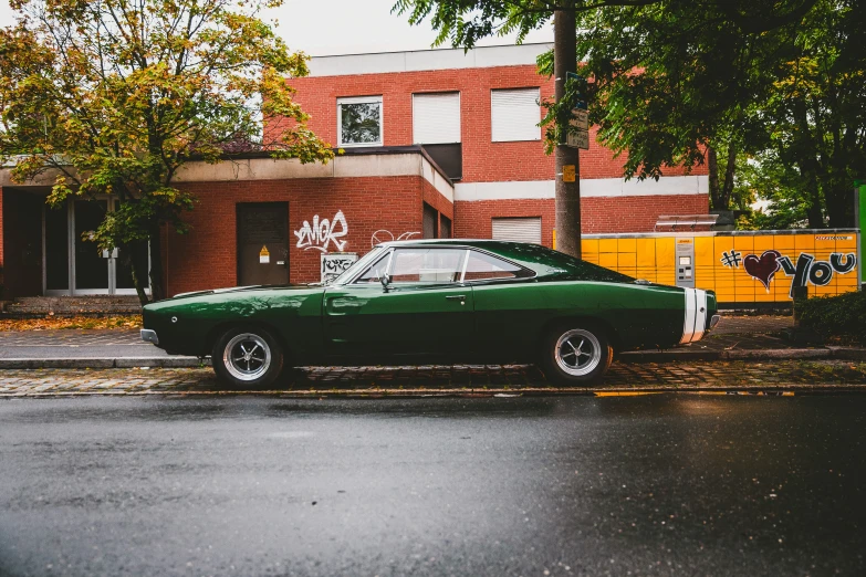 a green car sitting on the side of a street