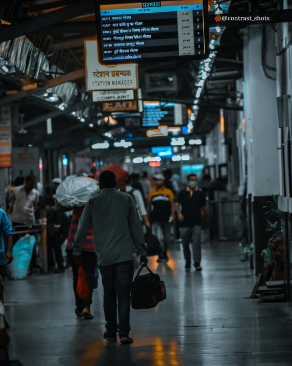 a busy station with people with their luggage walking