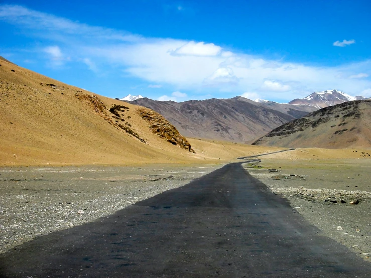 an empty road with mountains in the background