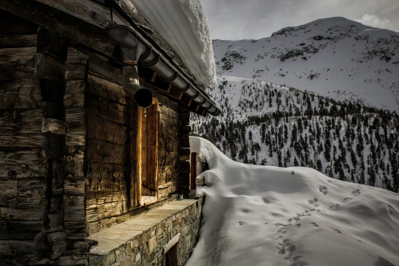 the cabin in the mountain with the mountain and sky covered by snow